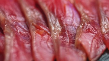 Düzgün dönen somon balığını yakın çekim, suşi pişirme - Philadelphia, taze çiğ ton balıklı yılan balığı tüttürme. Makro