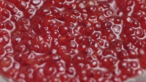 Roter Kaviar rotierte über schwarzem Hintergrund. Rotation des Lachskaviars in Großaufnahme. Feinkost. Textur von Kaviar. Meeresfrüchte. 4K-UHD-Video — Stockfoto
