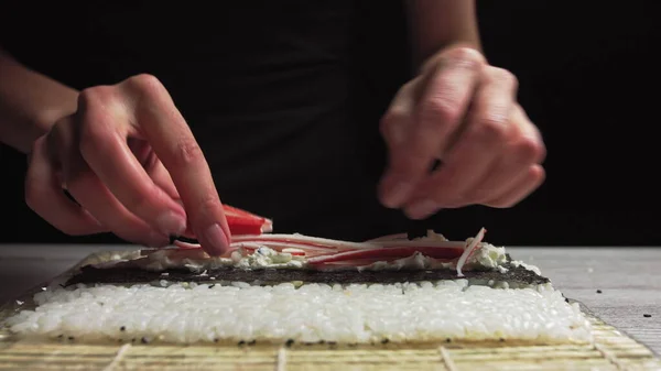 寿司大厨的特写把螃蟹放在诺里叶和螃蟹肉上。寿司的制作过程。 — 图库照片