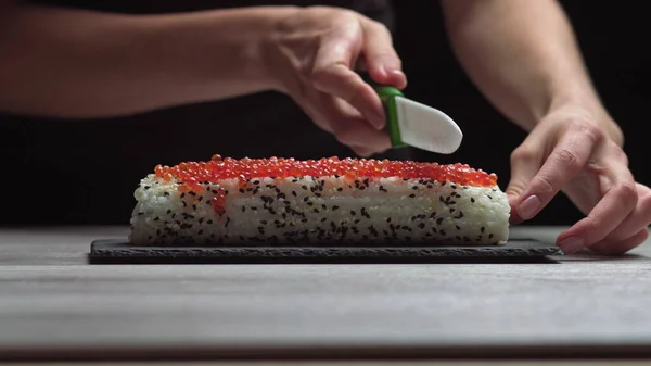 厨师用锋利的刀切寿司.寿司的烹调、准备过程。日本菜. — 图库照片