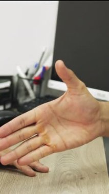 Yakın plan çekimde iki el titriyor, bir anlaşma ya da anlaşmanın göstergesi olarak, dikey kompozisyon anı yakalıyor. El sıkışma Gösterme Anlaşması