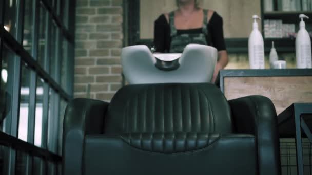 Man Sits On Chair And Puts His Had In A Sink At Hair Salon Male