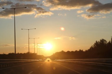 Güzel gün batımı ile asfalt karayolları yol kırsal sahnede. Akşam gökyüzünde büyük bulutlar