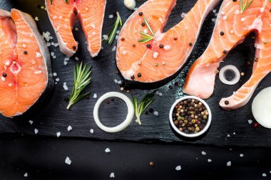 Somon steak, biber ve tuz, beton tablo, kopya alanı üstten görünüm otlar siyah taş