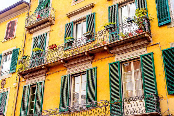 Facades with windows of houses of Pisa, on a sunny day