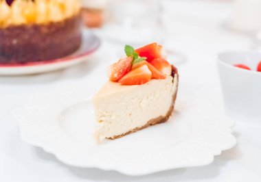 Beyaz arkaplanda bir dilim çilekli cheesecake, seçici odak, kare resim