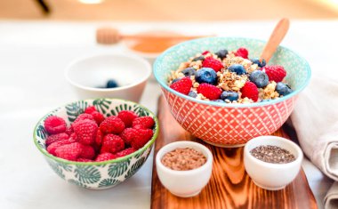 Yüksek proteinli sağlıklı kahvaltı, yaban mersinli karabuğday lapası, ahududu, keten tohumu ve bal yakın çekim görüntüsü.