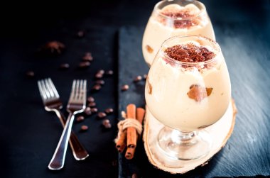 Geleneksel İtalyan tatlı Tiramisu koyu arka plan üzerine bir bardak