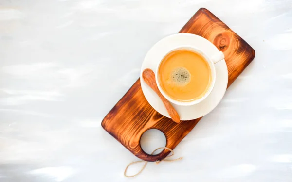 Tasse à café avec une cuillère en bois vue sur le dessus sur fond de table en bois — Photo
