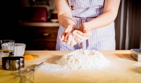 Facendo la pasta da mani femminili su tavolo di legno — Foto Stock