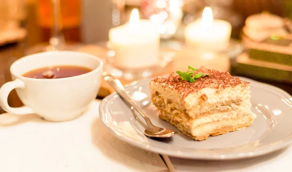 Tiramisù a lume di candela, appuntamento romantico in Italia, dessert tiramisù su un piatto di porcellana — Foto Stock