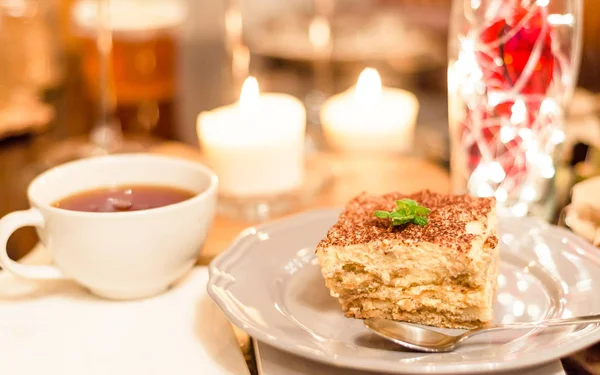 tiramisu by candlelight, romantic date in Italy, tiramisu dessert on a porcelain plate