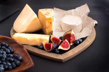 peynir rustik ahşap masa, keçi peyniri, chevre, grana padana, incir, yaban mersini türleri