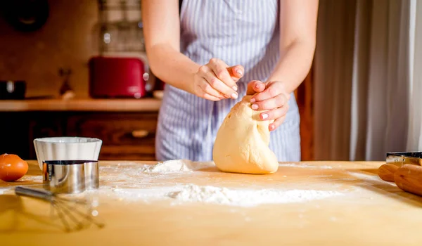 Жінки руки замішують тісто на столі — стокове фото