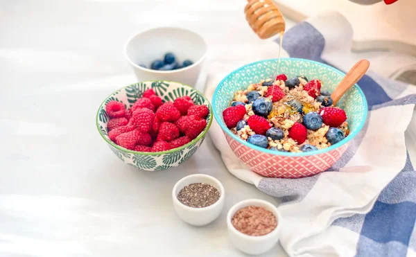 High protein healthy breakfast, buckwheat porridge with blueberries, raspberries, flax seeds and honey Closeup view