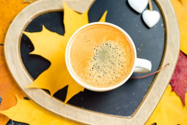 Sonbahar yaprakları ve ahşap masa fincan kahve.