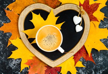 Sonbahar yaprakları ve ahşap masa fincan kahve.