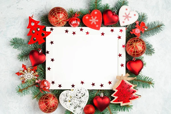 Noel ve yeni yıl çerçeve kompozisyon. Noel süslemeleri boş kopya alanı metin için beyaz zemin üzerine kırmızı renklerde. Kartpostal veya davet için tatil ve kutlama kavramı.