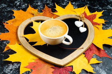 Sonbahar yaprakları ve ahşap masa fincan kahve.