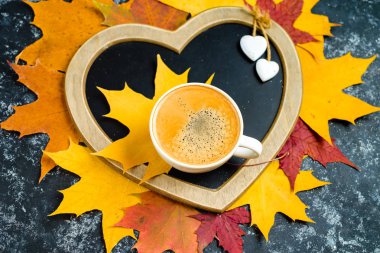 Sonbahar yaprakları ve ahşap masa fincan kahve.