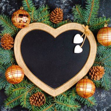 Yeni yıl Noel ağaç dalları ve yılbaşı ağacı süsleri ve bir kalp şeklinde bir çerçeve kompozisyonu