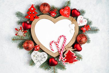 Kalp şeklinde bir Noel çerçevesi, fotokopi alanı olan yeni yıl ağacı süslemeleriyle çevrilidir. Üst manzara, düz uzanma.