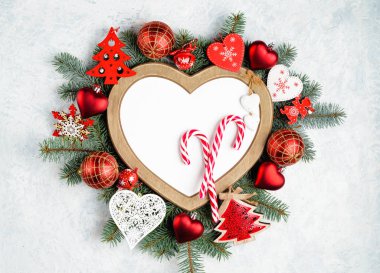 Kalp şeklinde bir Noel çerçevesi, fotokopi alanı olan yeni yıl ağacı süslemeleriyle çevrilidir. Üst manzara, düz uzanma.