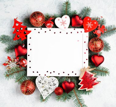 Noel ve yeni yıl çerçeve kompozisyon. Noel süslemeleri boş kopya alanı metin için beyaz zemin üzerine kırmızı renklerde. Kartpostal veya davet için tatil ve kutlama kavramı.