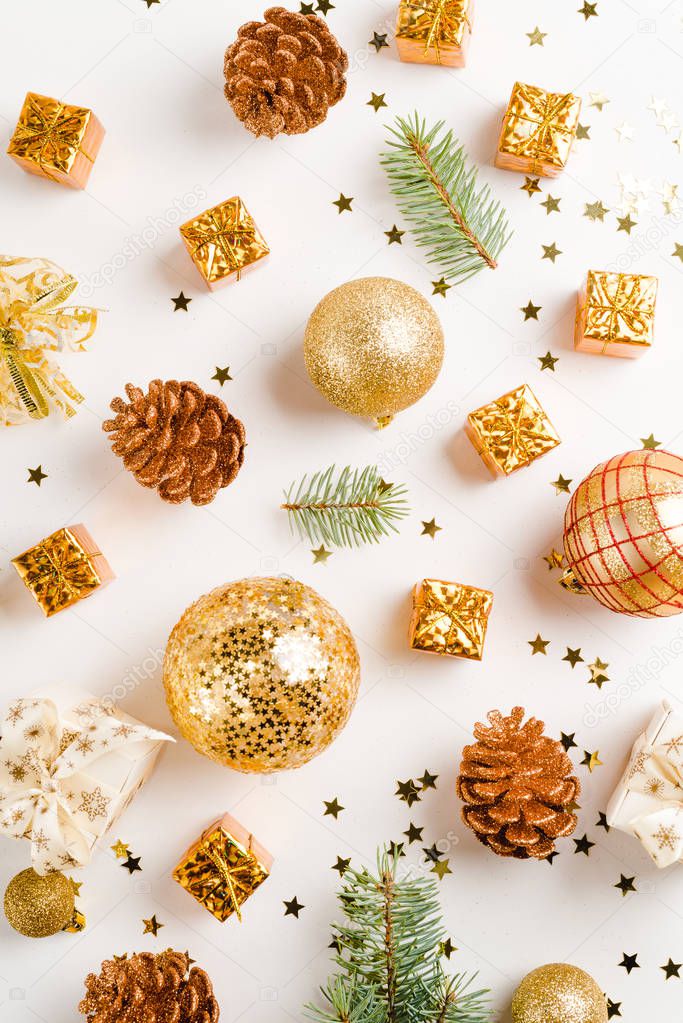 christmas or new year composition. christmas decorations in gold colors on white background with empty copy space for text. holiday and celebration concept for postcard or invitation.