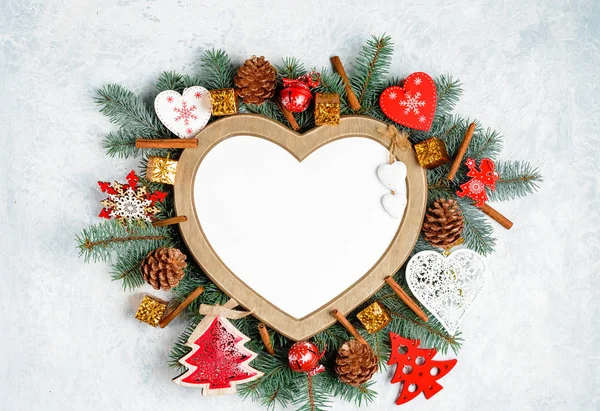 一个心形的圣诞框架被一个带有复制空间的圣诞树枝条环绕着 — 图库照片