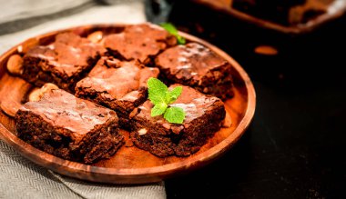 Parça ev yapımı karanlık çikolatalı kek ile badem dilimleri tepesi yığını ve nane kopya alanı ahşap tablo.
