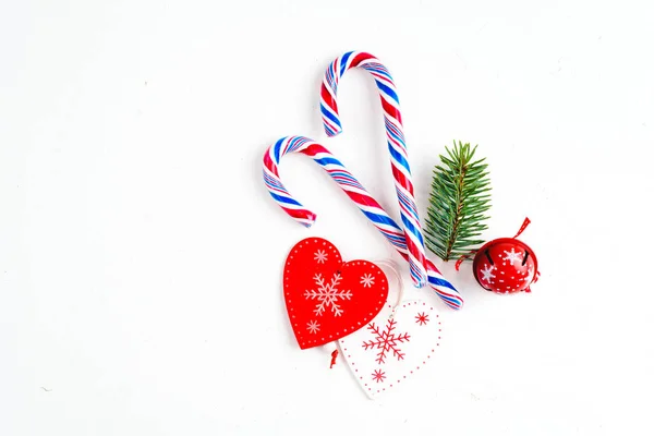Weihnachtskomposition mit Weihnachtsbonbons, Baumzweigen und Weihnachtsschmuck auf weißem Hintergrund. Flache Lage, Draufsicht. — Stockfoto