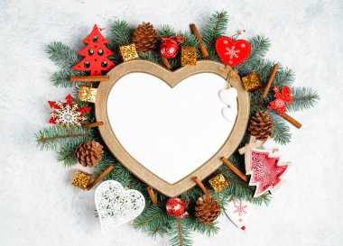 Noel çerçeve bir kalp şeklinde dalları bir yılbaşı ağacı Noel süslemeleri kopya alanı ile çevrilidir. Üstten Görünüm, düz yatıyordu. Doğa yeni yıl kavramı.