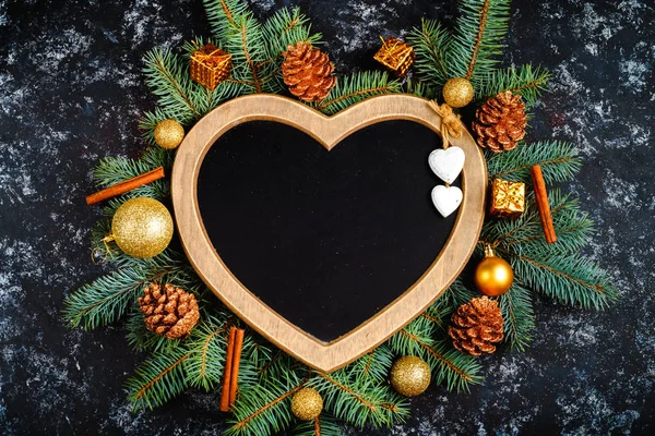 Neujahr Komposition aus Christbaumzweigen und Christbaumschmuck und Rahmen in Herzform, Draufsicht, Platz für Text, flache Lage — Stockfoto