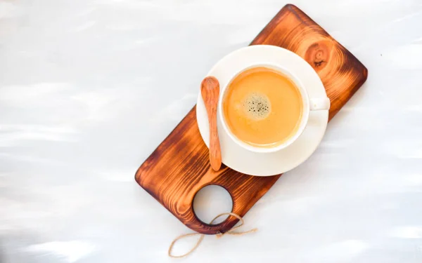 Tasse à café avec une cuillère en bois vue sur le dessus sur fond de table en bois — Photo