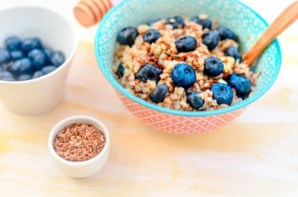 High protein healthy breakfast, buckwheat porridge with blueberries, flax seeds and honey
