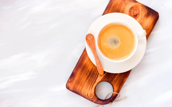 Tasse à café avec une cuillère en bois vue sur le dessus sur fond de table en bois — Photo