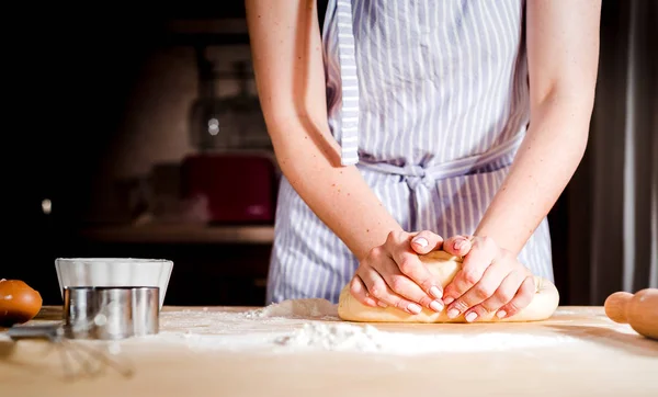 As mãos de mulher amassam a massa de farinha em uma mesa — Fotografia de Stock