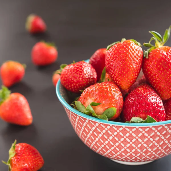 Erdbeeren in der Schüssel auf schwarzem Hintergrund — Stockfoto