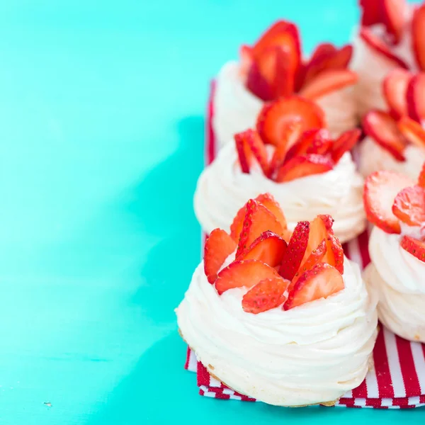 Gyönyörű Pavlova sütemények eper kék háttér. Szelektív fókusz. Ízletes édes breackfast. Esküvő reggel. Habcsók tejszínnel. — Stock Fotó