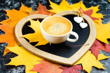 Sonbahar yaprakları ve masaya fincan kahve. Sonbahar yaprak kompozisyon kalpli çerçeve şeklinde. Kopya alanı.