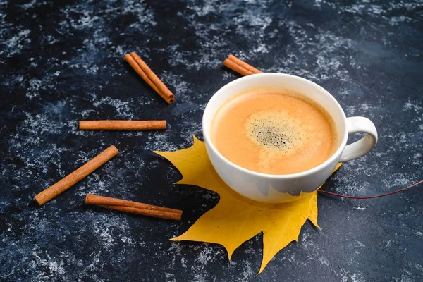 Composición de café de otoño, taza de café con espuma, canela, hoja de otoño en fondo negro. Bebidas calientes de otoño, café y concepto de bar — Foto de Stock