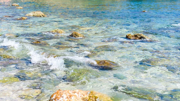 Фон прозрачной морской воды и дна, с камнями и волнами — стоковое фото