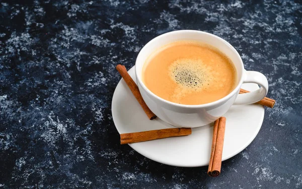 Tasse de café avec mousse à la cannelle sur fond noir — Photo