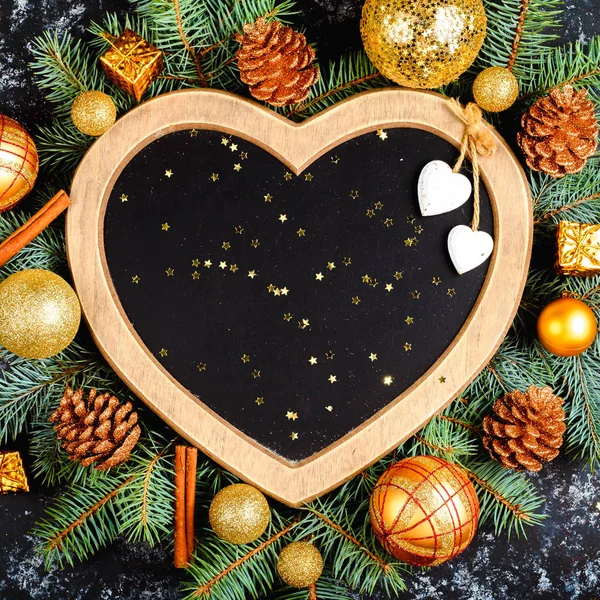 Fondo de Navidad - decoraciones y rama de abeto en una mesa, un marco en forma de corazón, vista superior, lugar para el texto, laico plano, tarjeta de Navidad —  Fotos de Stock