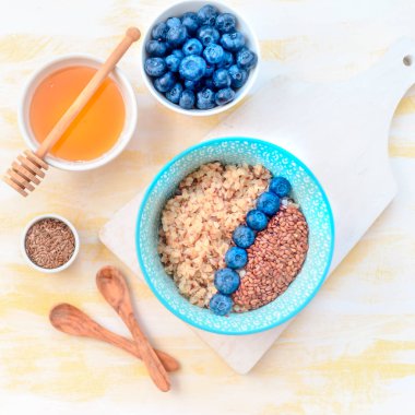 Sağlıklı kahvaltı malzemeleri. Beyaz ahşap arka plan üzerine karabuğday yaban mersini nane bal, üst görünüm, kopya alanı