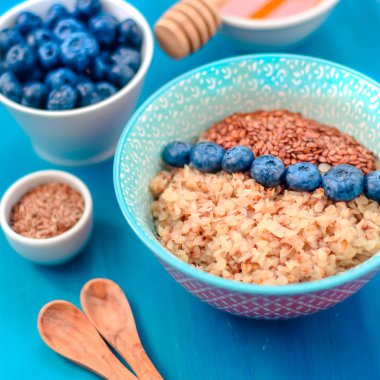 Sağlıklı kahvaltı malzemeleri. Beyaz ahşap arka plan üzerine karabuğday yaban mersini nane bal, üst görünüm, kopya alanı