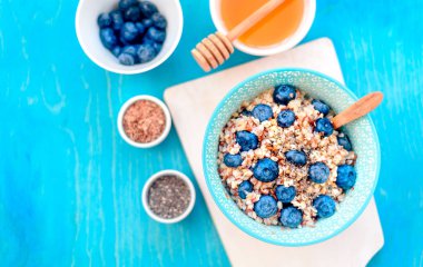 Sağlıklı kahvaltı malzemeleri. Beyaz ahşap arka plan üzerine karabuğday yaban mersini nane bal, üst görünüm, kopya alanı