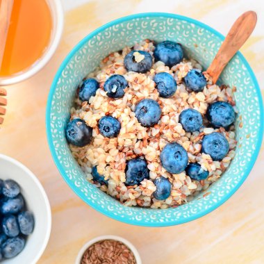 Sağlıklı kahvaltı malzemeleri. Beyaz ahşap arka plan üzerine karabuğday yaban mersini nane bal, üst görünüm, kopya alanı