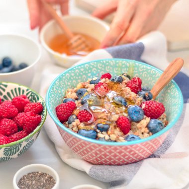 Yüksek proteinli sağlıklı kahvaltı, yaban mersinli karabuğday lapası, ahududu, keten tohumu ve bal.